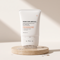 Hair Revive Brush Serum 100 ml on a travertine stone plinth